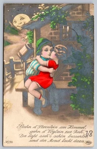 1920s Little Boy & Girl Kissing Smiling Moon German Hand Colored RPPC Postcard - Bild 1 von 2