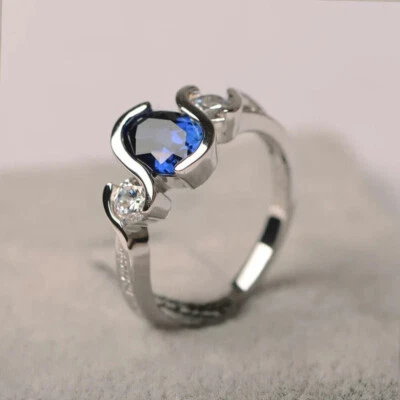 Anillo de compromiso de tres piedras con diamantes de zafiro azul ovalado de 2 quilates acabado en oro blanco de 14 k Foto 1 de 4