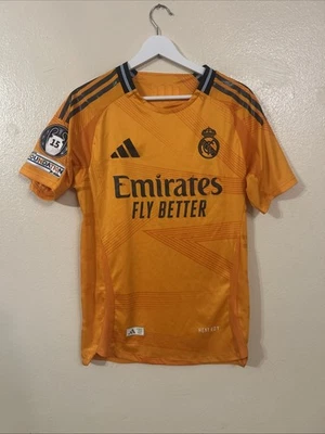 Adidas Real Madrid Naranja Réplica Visitante Vini Jr. #7 Con Parches UCL Talla Pequeña Foto 1 de 4