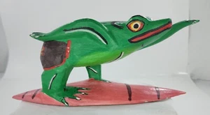 Handgeschnitzter Holzfrosch auf rosa Surfbrett mit braunen Streifen handbemalt - Bild 1 von 7