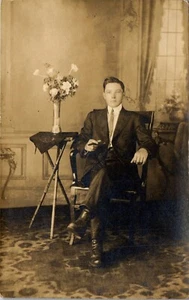  Alfombra de colección RPPC foto postal estudio pose hombre con cigarro, florero - Imagen 1 de 3