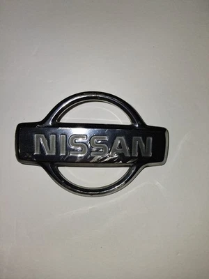 NISSAN XTERRA FRONT CHROME GRILLE EMBLEM 1999-2001  FACTORY OEM USED  - Image 1 of 3