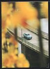 Blauer Schrägheck-VW auf einer Flussbrücke, Ansichtskarte 