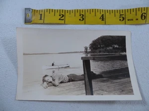Foto instantánea gay divertida de colección años 40 años 50 hombre dormido en muelle hombre en bote de remos en blanco y negro - Imagen 1 de 2