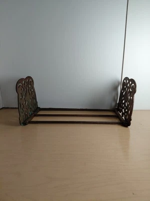 Antiguo estante para libros Art Nouveau de hierro fundido con acabado de latón ornamentado extremos deslizantes  Foto 1 de 4