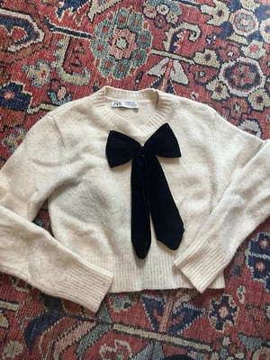 Suéter Zara Holiday Crema con Lazo de Terciopelo Negro Foto 1 de 3