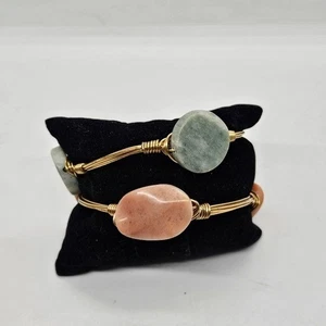 pair of gold tone wire bangles with light green and orange stones - Picture 1 of 5