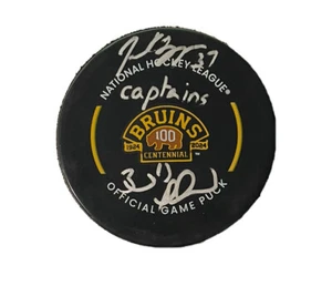 Bergeron/Marchand Dual Signed Insc. “Captains” Bruins Centennial Game Puck; 1/10 - Picture 1 of 2