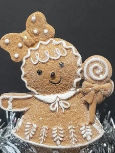 Lebkuchenmädchen mit Schleife im Haar, hält einen Lutscher, bestäubt in Glitzer  - Bild 1 von 4