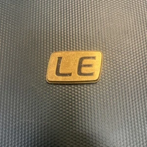 Placa de identificación con logotipo emblema LE dorado de 1,50 unidades Toyota de varios vehículos - Imagen 1 de 6