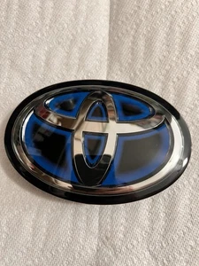 2021-2023 TOYOTA COROLLA HYBRID GRILL FRONT EMBLEM 90975-02124 / 02136 OEM BLUE - Picture 1 of 3