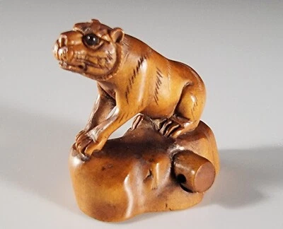 Antiguo tigre reclinable japonés de boj Netsuke de la era Meiji sobre roca firmado Foto 1 de 4