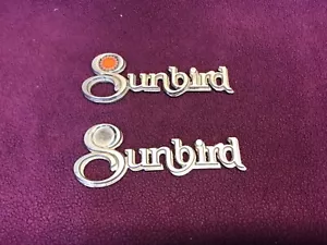 Pontiac Sunbird 1976-1980 guardabarros emblema insignia conjunto 2 OE GM - Imagen 1 de 5