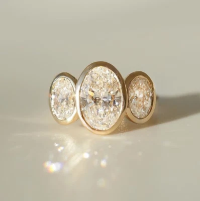Anillo de tres piedras con bisel de moissanita de corte ovalado 3TCW en oro amarillo sólido de 10K Foto 1 de 4