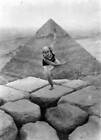 Woman dancing on the Sphinx A pyramid can be seen in the background Old Photo