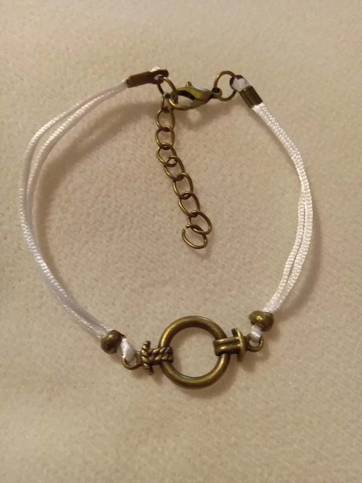 Pulsera con cordón de nailon blanco con dije de anillo tórico de bronce Foto 1 de 1