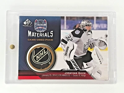 2014-15 SP Game Used - Jonathan Quick - Stadium Series Materials Puck - Image 1 of 2