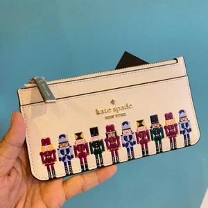 Tarjetero Kate Spade Oh What Fun Cascanueces Grande Delgado KJ071 - Imagen 1 de 4
