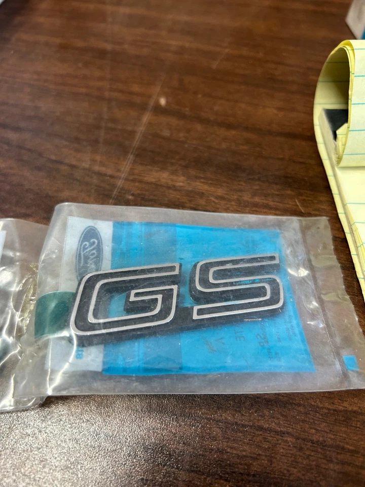 E1YY-16098-A ''GS'' 1981-1987 MERCURY LYNX ''GS'' FRONT FENDER NAMEPLATE NEW NOS Foto 1 de 3