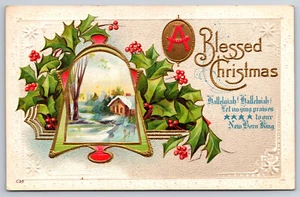 A638 Vtg Embossed Postcard Christmas Bell Holly Snow Scene Cabin Tree Post 1915 - Picture 1 of 2