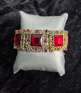 Brazalete elástico Bijoux Terner tono dorado con detalles de piedras preciosas rojas y diseño intrincado - Imagen 1 de 6