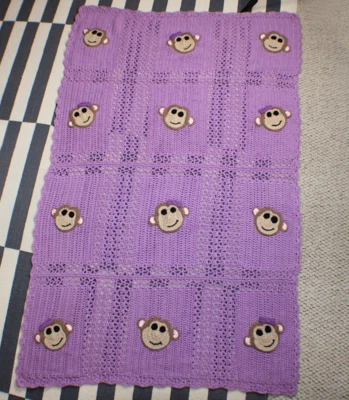 Manta infantil púrpura de ganchillo con apliques de mono de niña y niño de ganchillo Foto 1 de 4