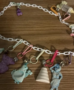 Vintage 1980er rosa Gliederkette mit 11 Kunststoff Clip auf Glocke Charms Klavier Medaille - Bild 1 von 8