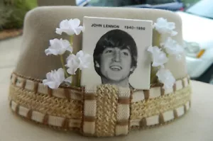 Stetson Cowboyhut mit John Lennon Pin umgeben von Blumen - Bild 1 von 9
