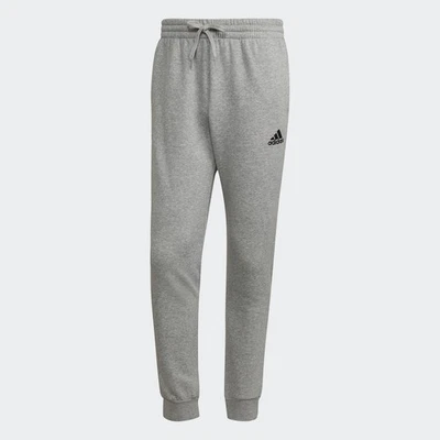 Pantalones cónicos regulares de vellón Adidas Essentials para hombre Foto 1 de 2