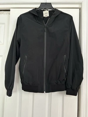 Chaqueta cortavientos H&M talla XS negra lisa con capucha cremallera frontal con bolsillos con cremallera Foto 1 de 4