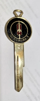 Oldsmobile llave GM esmaltada dorada en blanco Foto 1 de 4