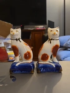 Par de gatos Staffordshire Calico en almohadas azules 1 tiene oreja astillada firmada - Imagen 1 de 12