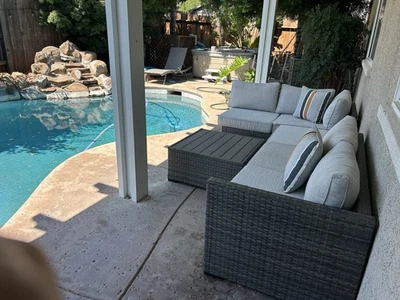 Grey woven couch, Light grey seats, striped pillows in blue, orange, gray tones. - Image 1 of 2