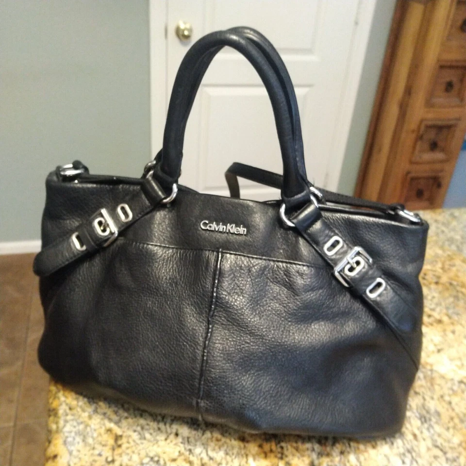 Bolso de hombro convertible de cuero granulado negro Calvin Klein con acento de hebilla Foto 1 de 4