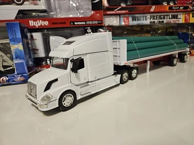 VOLVO VN-780 WITH FLATBED TRAILER HAULING LONG PIPES 1/32 scale NEW RAY  - Image 1 of 4
