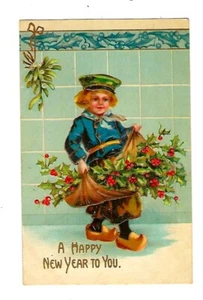 Postal de Año Nuevo de principios de 1900 niño holandés llevando un paquete de acebo en relieve - Imagen 1 de 2