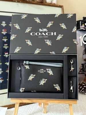 MUÑEQUERA CON CREMALLERA EN ESQUINA EN CAJA CON ESTAMPADO DE BÚHO DE FIESTA (COACH F80302) SV/NEGRO MULTI Foto 1 de 4