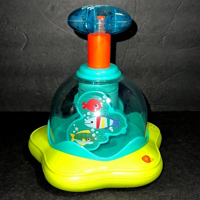 Top giratorio Bright Starts Press & Glow con luces y música edades 6-36 meses  Foto 1 de 4