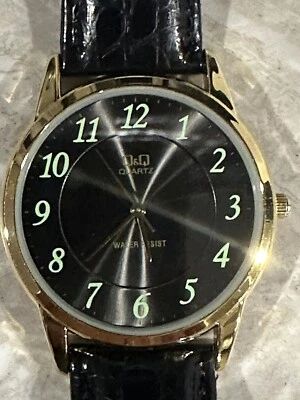 QQ Esfera Negra Nueva Batería Redonda Tono Dorado Estuche Negro Imitación Cuero Banda Reloj A Foto 1 de 4