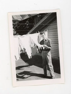 Man holding woman's laundry on clothesline - vintage snapshot found photo - Picture 1 of 3