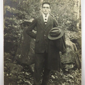 Real Photo Postcard RPPC Handsome Dapper Man Holding Hat Outside Woods Rocks - Picture 1 of 4