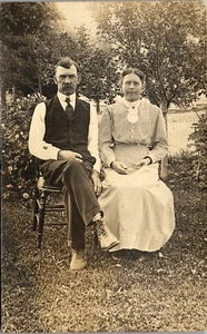 Vintage RPPC Foto Postkarte Paar sitzt im Garten auf Stühlen um 1910 - Bild 1 von 3