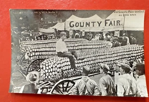 RPPC POSTCARD ~MAN RIDING GIANT CORN ON WAGON ~ IOWA COUNTY FAIR ~ EXAGGERATED - Picture 1 of 2