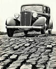 The Front Of A Chevrolet Automobile Standing On A Cobbled Road. It- Old Photo