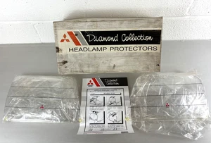 MITSUBISHI L200 1999-2006 PAIR OF HEADLIGHT PROTECTORS LENSE COVERS NEW GENUINE - Picture 1 of 6