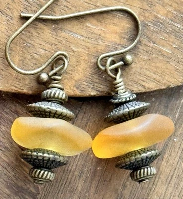 Pendientes colgantes de cuentas de vidrio africano amarillo dorado y bronce grabado. Boho Chic. Foto 1 de 3