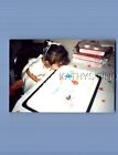 FOUND COLOR PHOTO E+0426 GIRL IN DRESS BLOWING OUT CANDLES ON BALLOONS CAKE