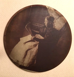 Antique 6" Round Columbia Portrait Tin Button GRANNY IN ROCKING CHAIR WITH PAPER - Picture 1 of 2