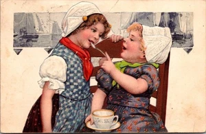 CHICAS HOLANDESAS compartiendo té en silla MOLINOS DE VIENTO c1907 postal en relieve - Imagen 1 de 2