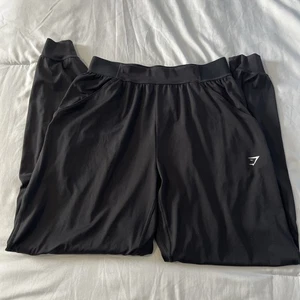 Pantalones de chándal Gymshark para mujer de rendimiento de entrenamiento con logotipo negro bolsillos elásticos medianos - Imagen 1 de 18